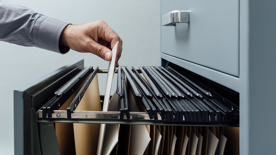 A records custodian searching through a filing cabinet